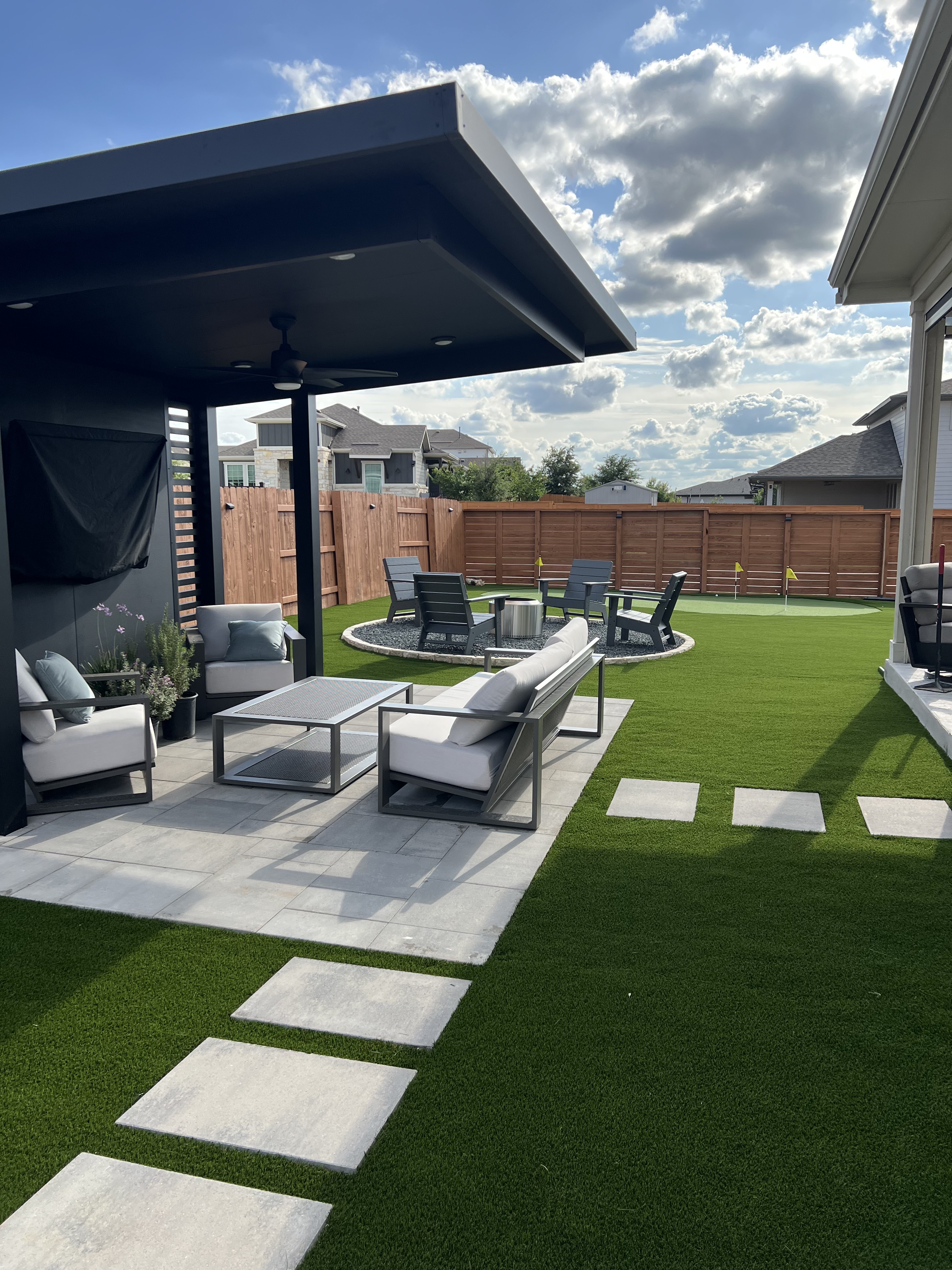 EZ Par creates a backyard with artificial turf, a custom putting green, hardscape, and outdoor living space in Greater Houston or Austin